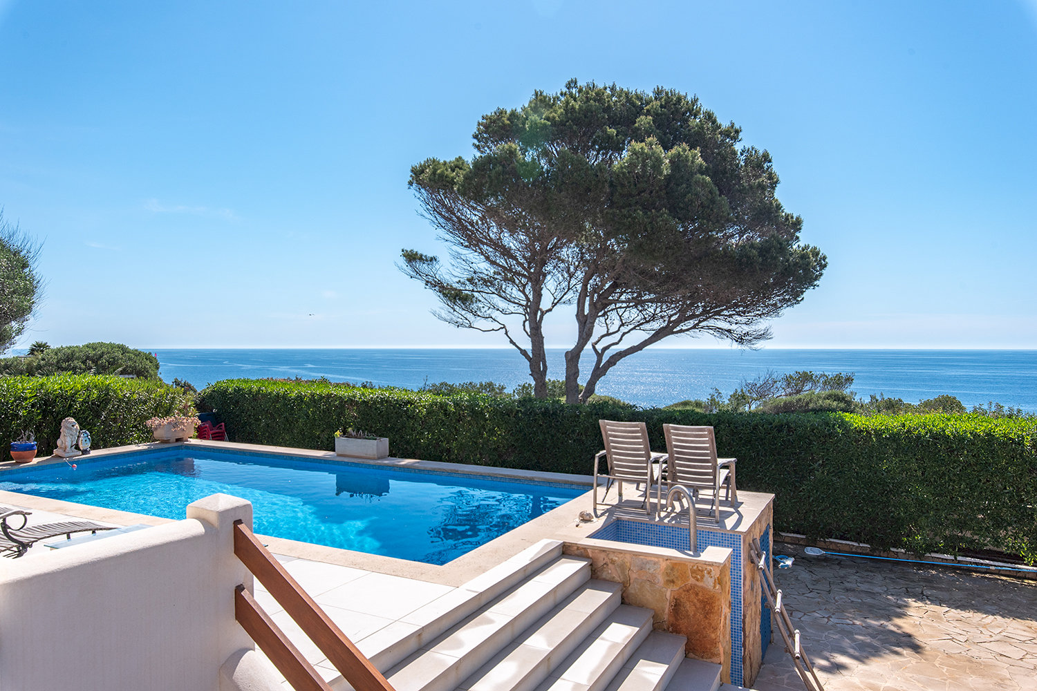 Stylish pool area with lounge zones and direct sea views