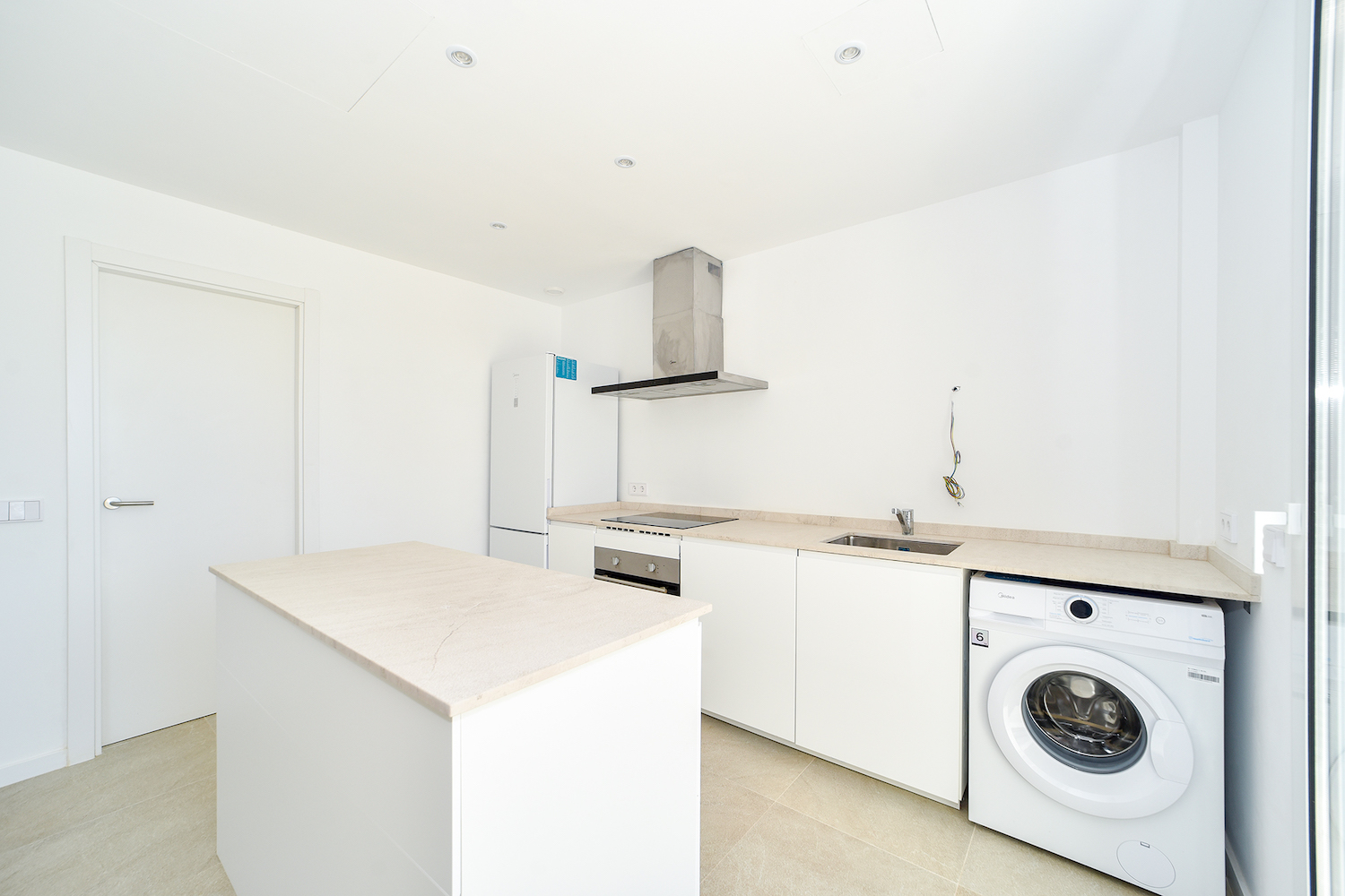 Bright kitchen area with central island and practical connection to the living space