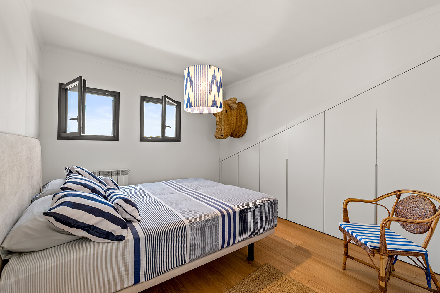 Bright double bedroom with bespoke fitted wardrobes, parquet flooring and maritime-inspired interiors