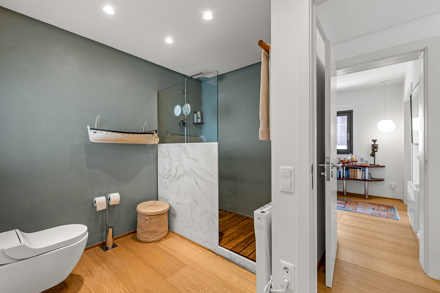 Spacious bathroom with walk-in rain shower, glass partition and contemporary design
